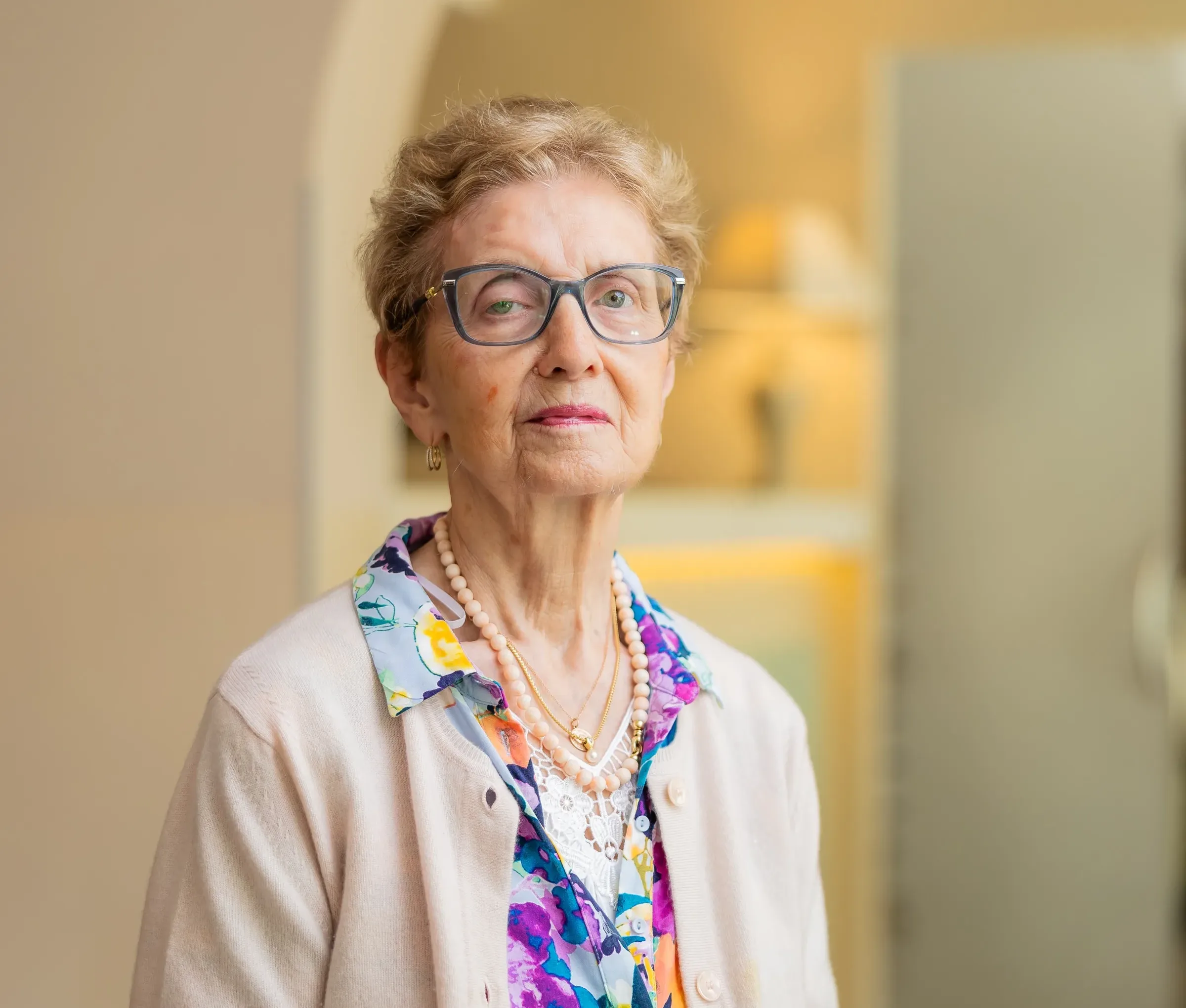 Ältere Dame mit Brille und Perlenkette