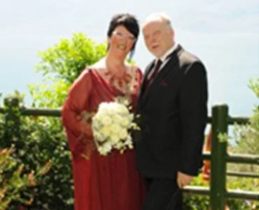 Älteres Hochzeitspaar posiert im Freien an einem sonnigen Tag