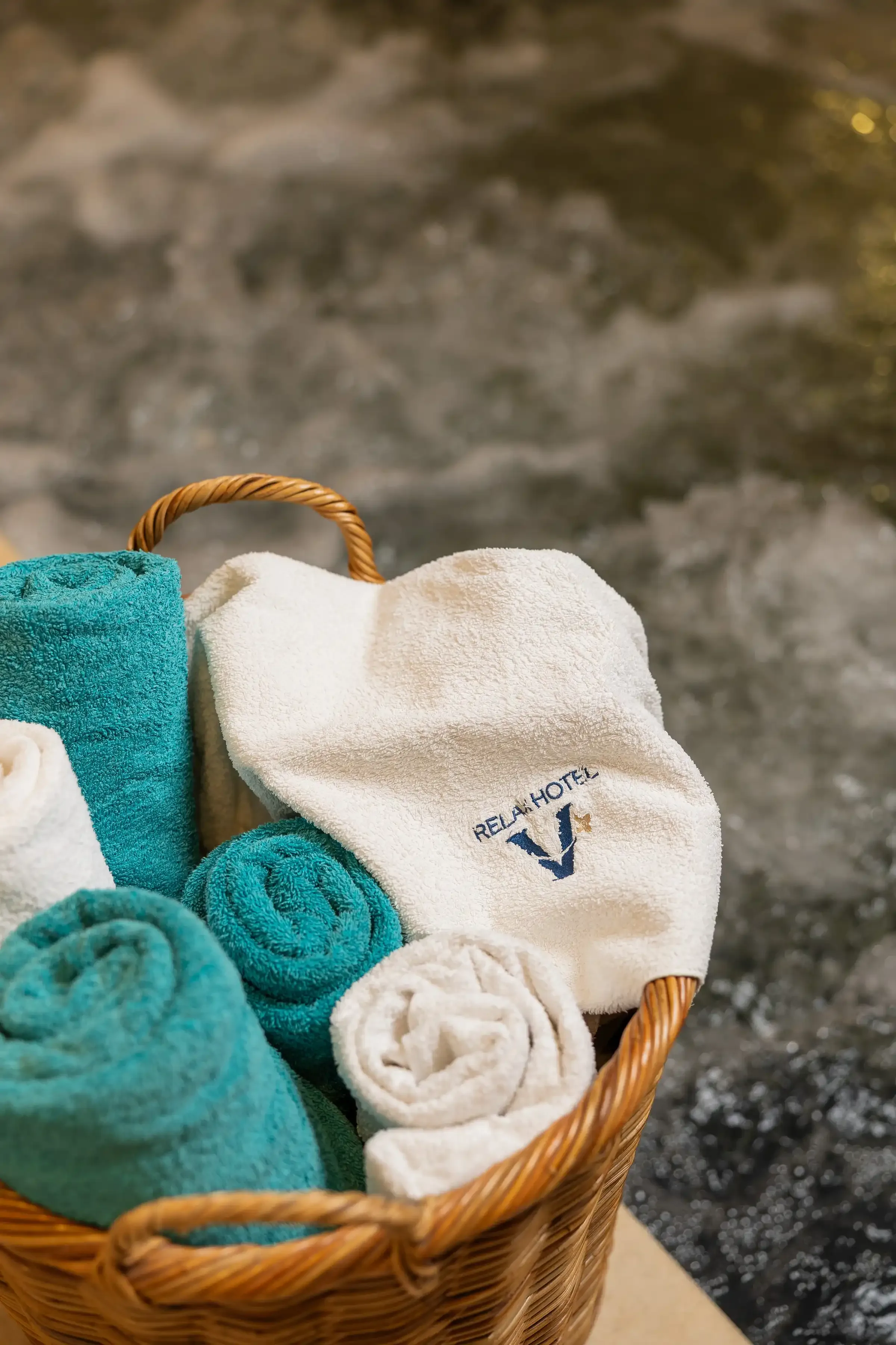 Cestino con asciugamani arrotolati in una spa di hotel