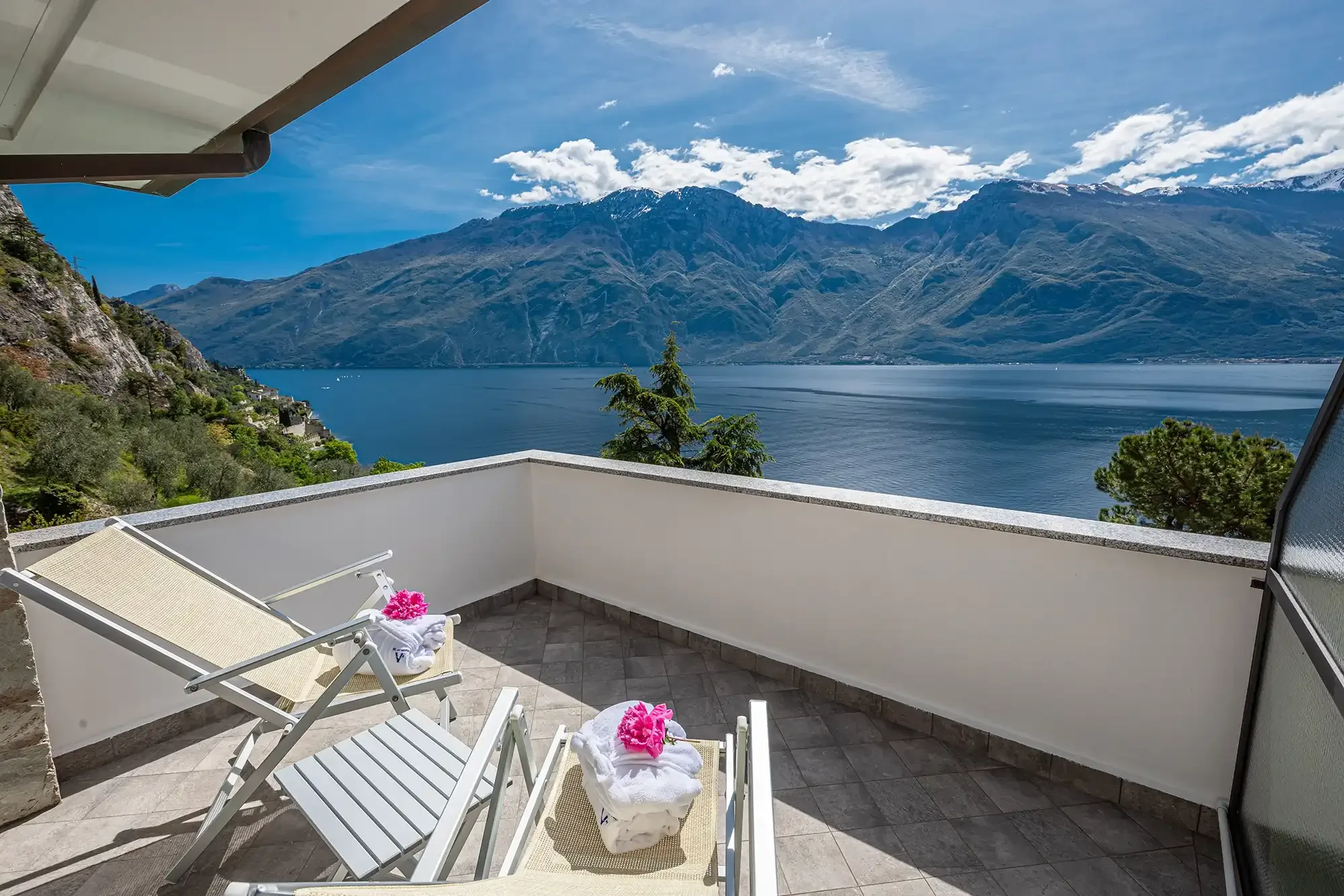 Balcon avec chaises longues face au lac et montagnes