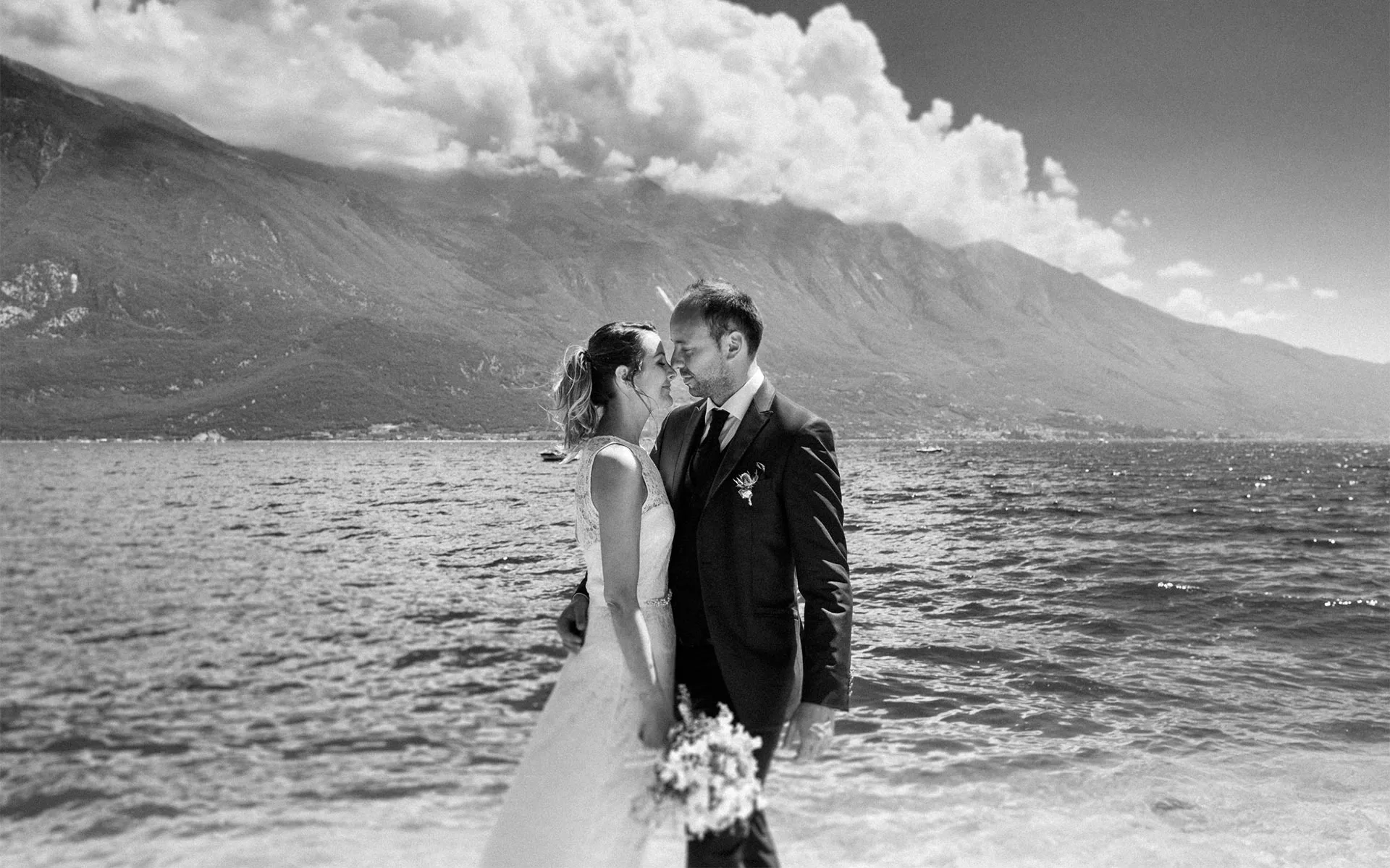 Wedding couple standing by the beach with mountain background