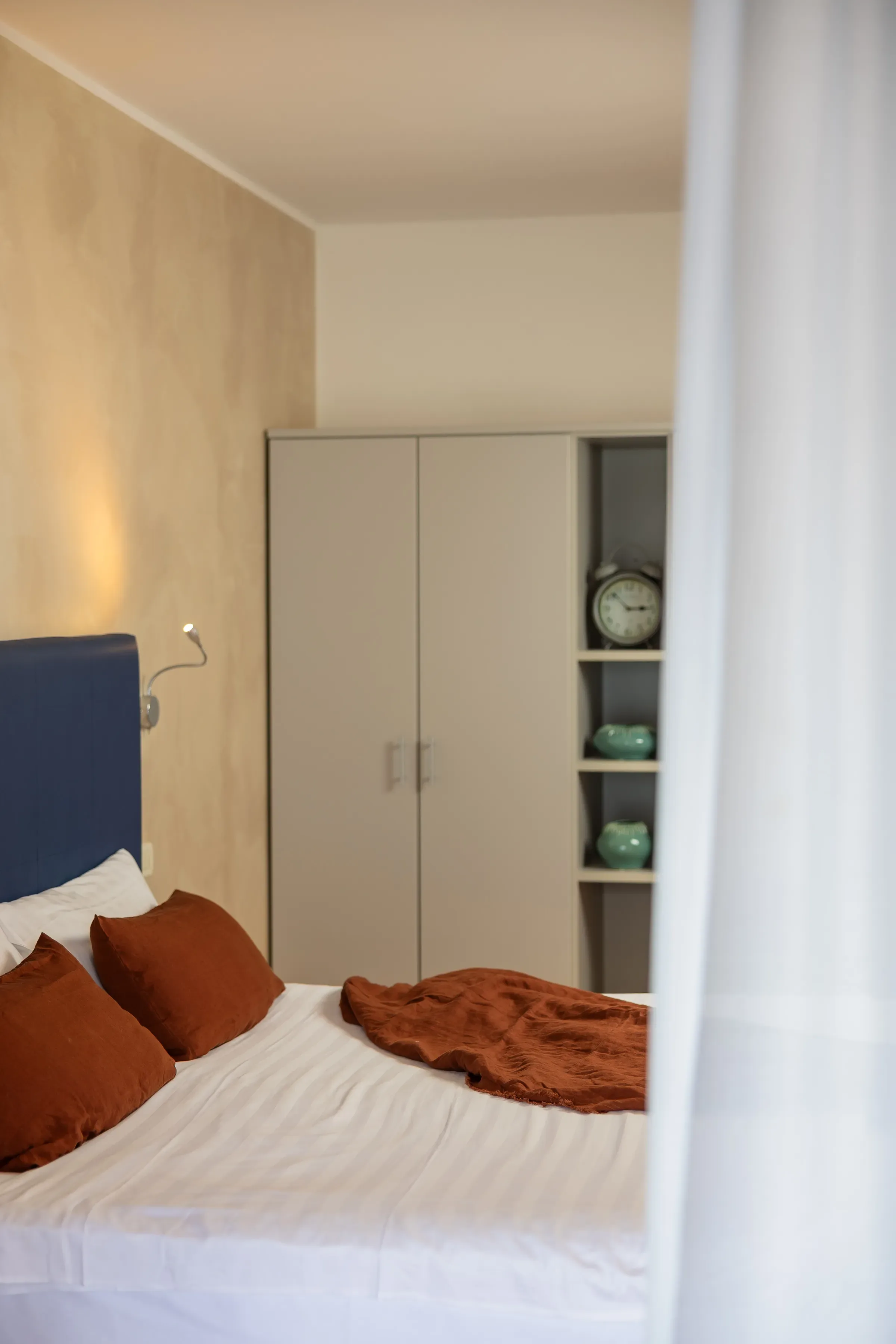 Camera da letto moderna con letto matrimoniale e cuscini marroni