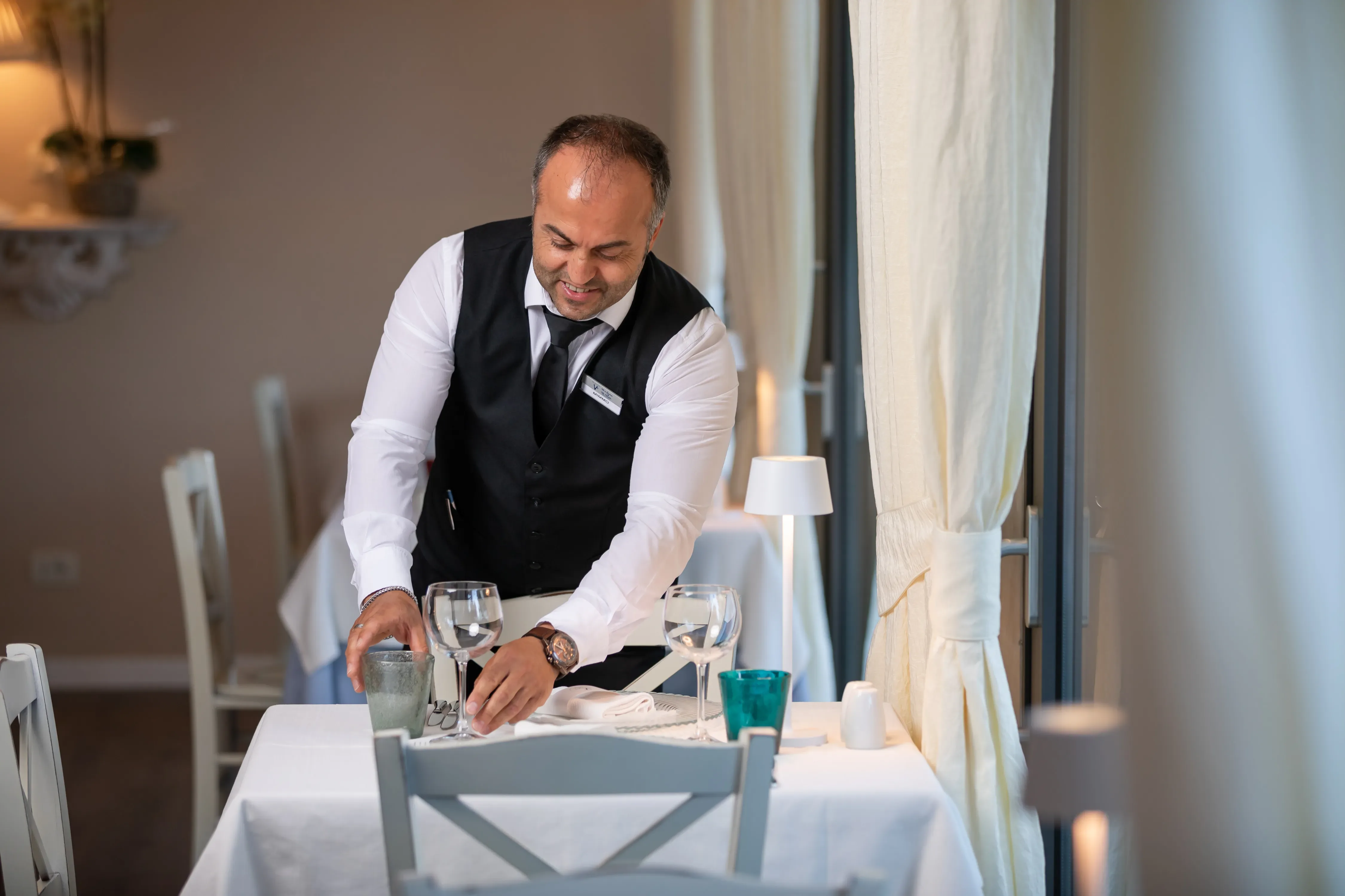 Cameriere che prepara un tavolo in un ristorante elegante