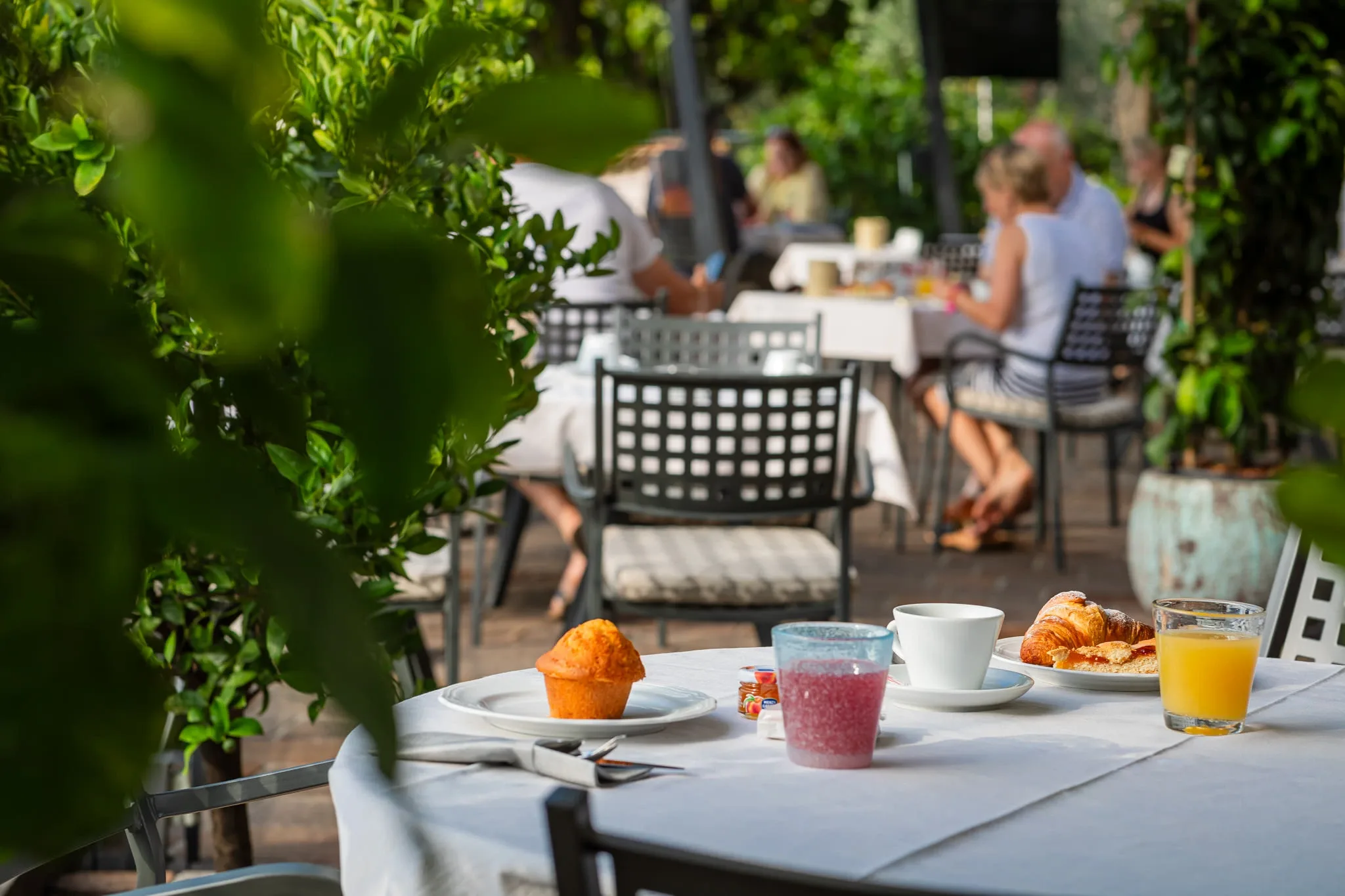 Colazione all'aperto con croissant, muffin e succhi su tavolo apparecchiato