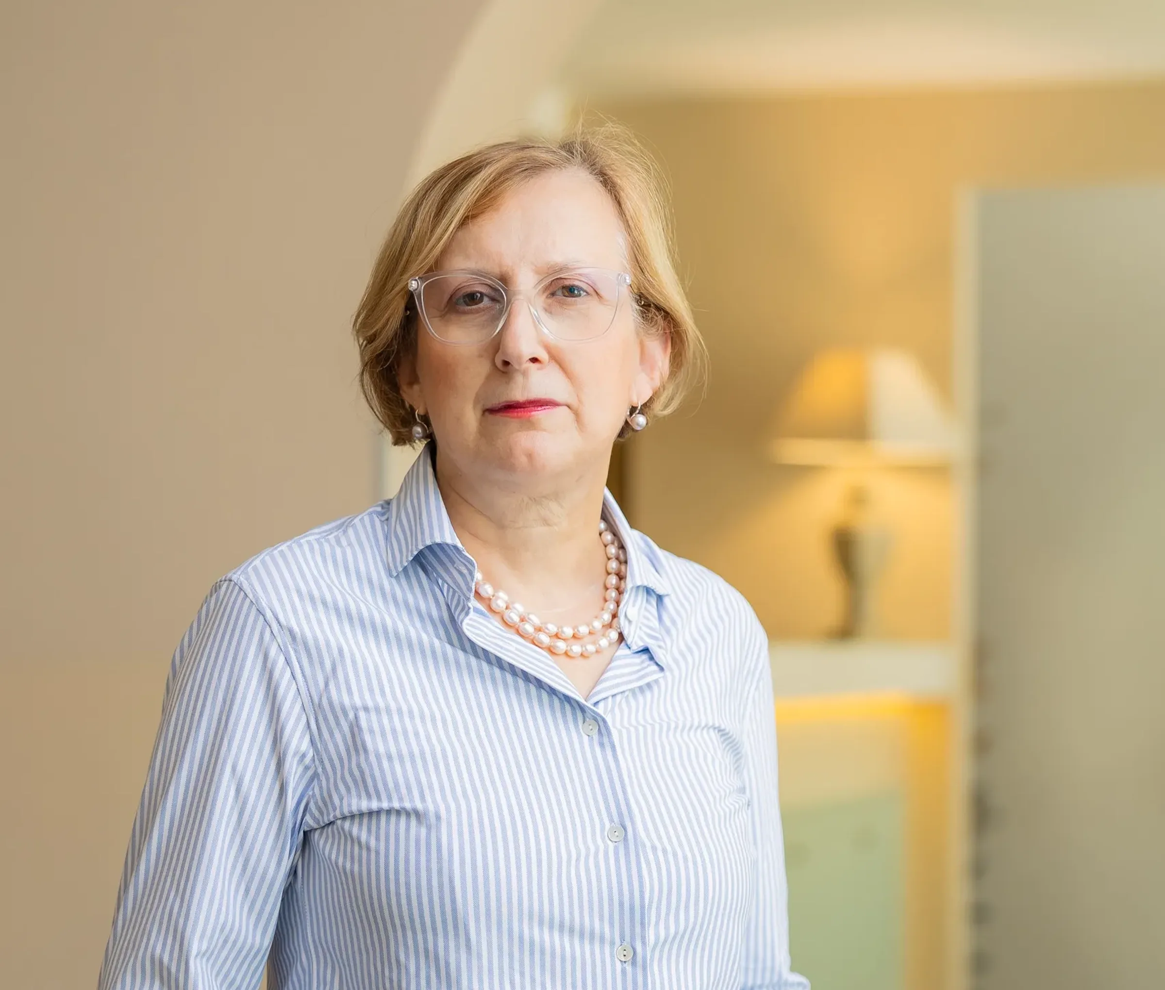 Dojrzała kobieta w okularach i naszyjniku z pereł