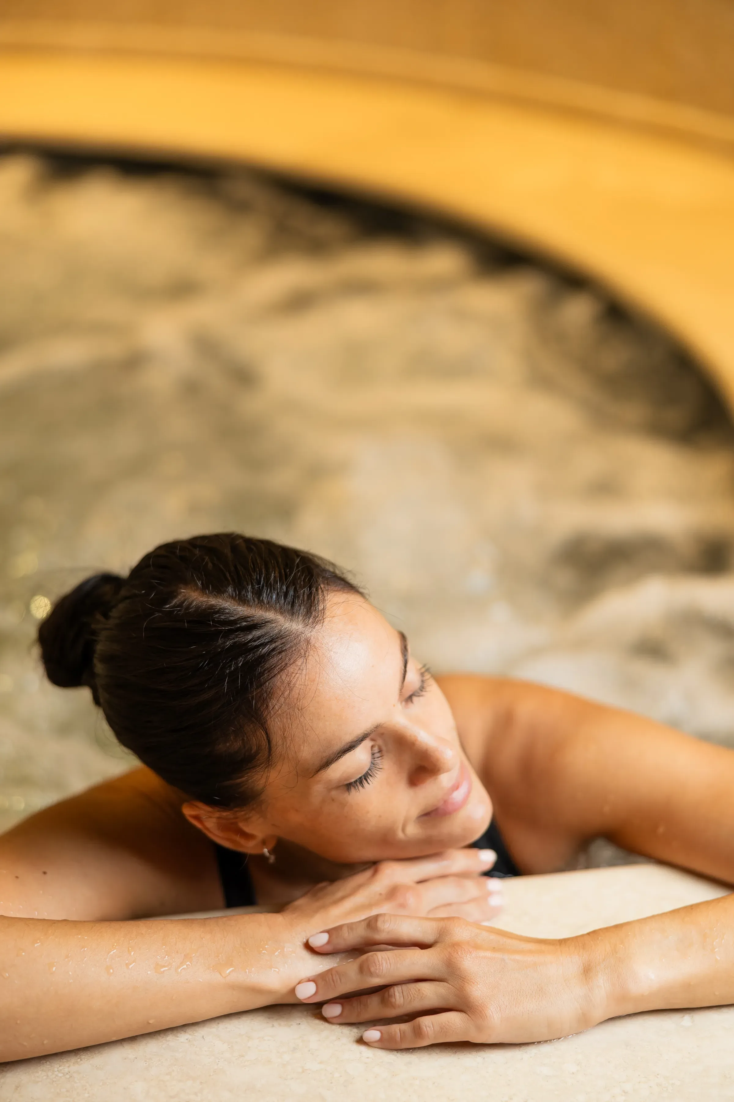 Femme détendue appuyée sur le bord d’un spa