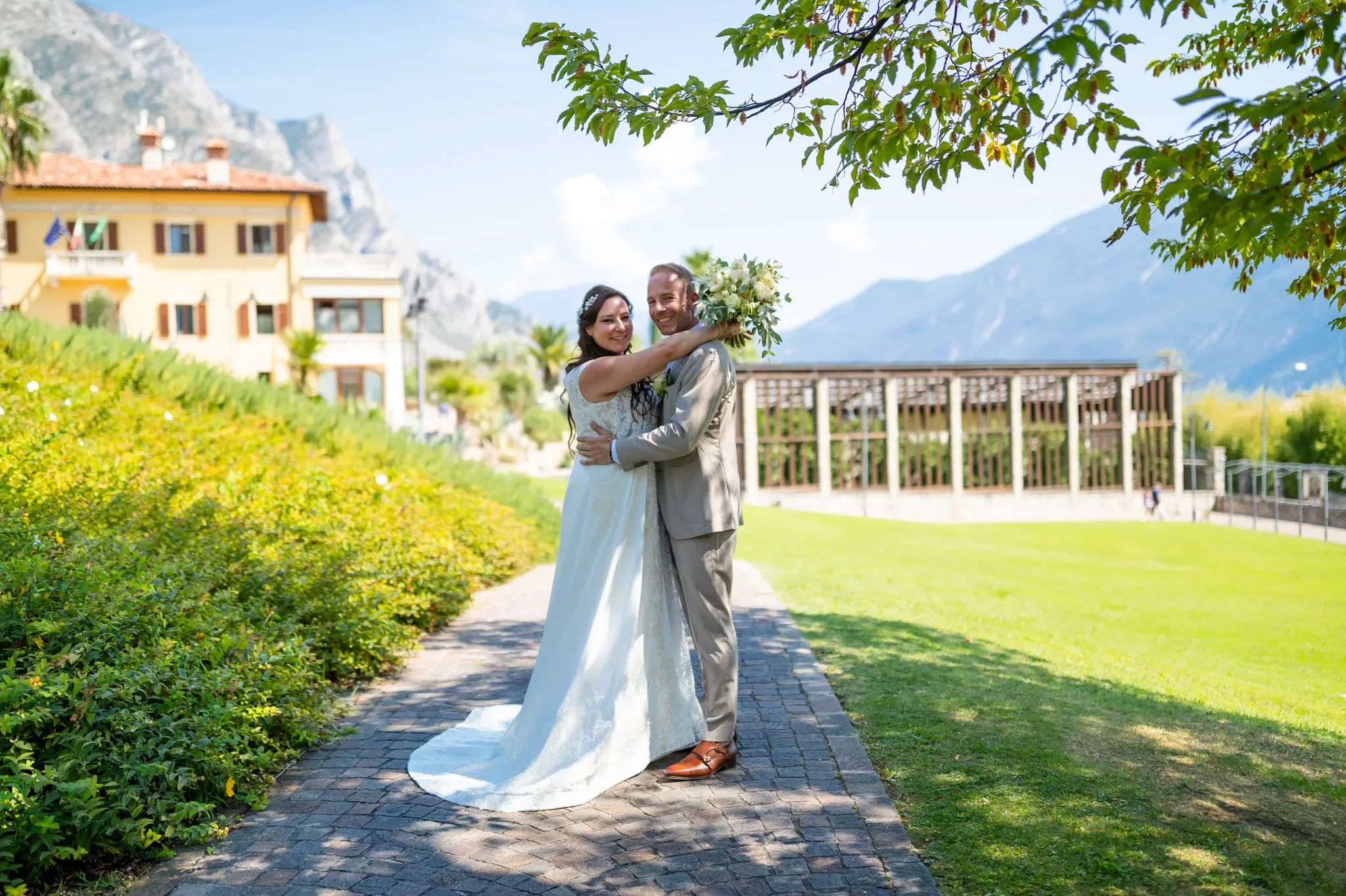 Happy wedding couple posing in a scenic garden with mountains