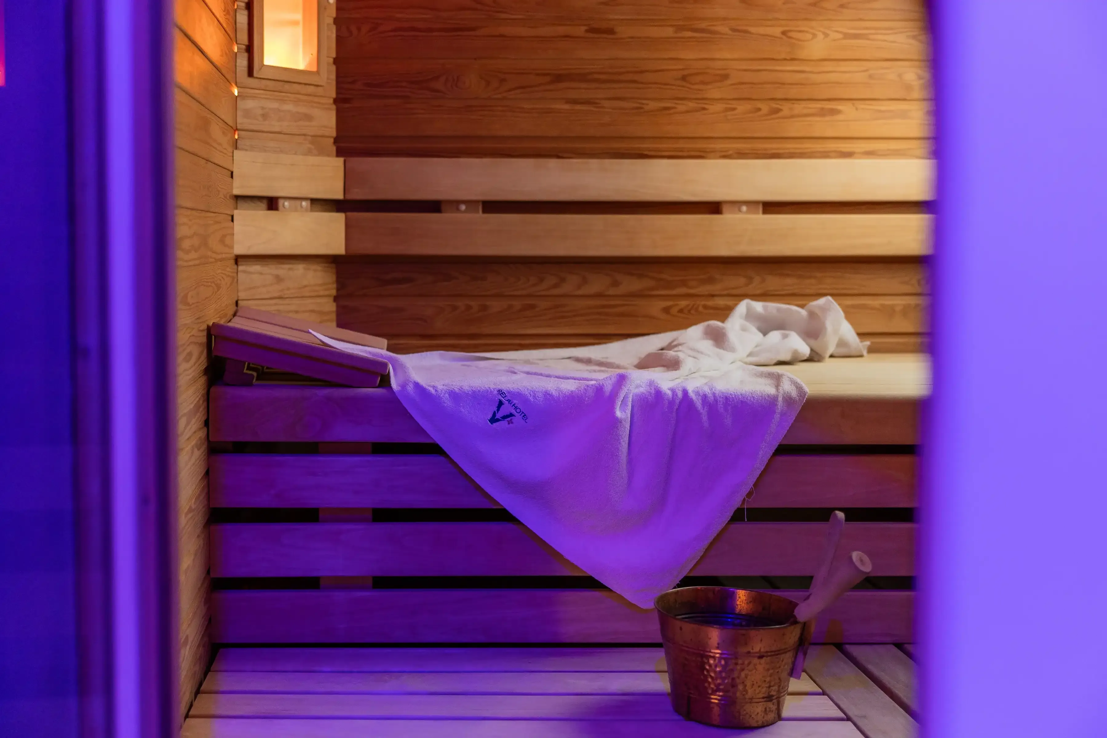 Intérieur de sauna en bois avec serviette et seau en cuivre