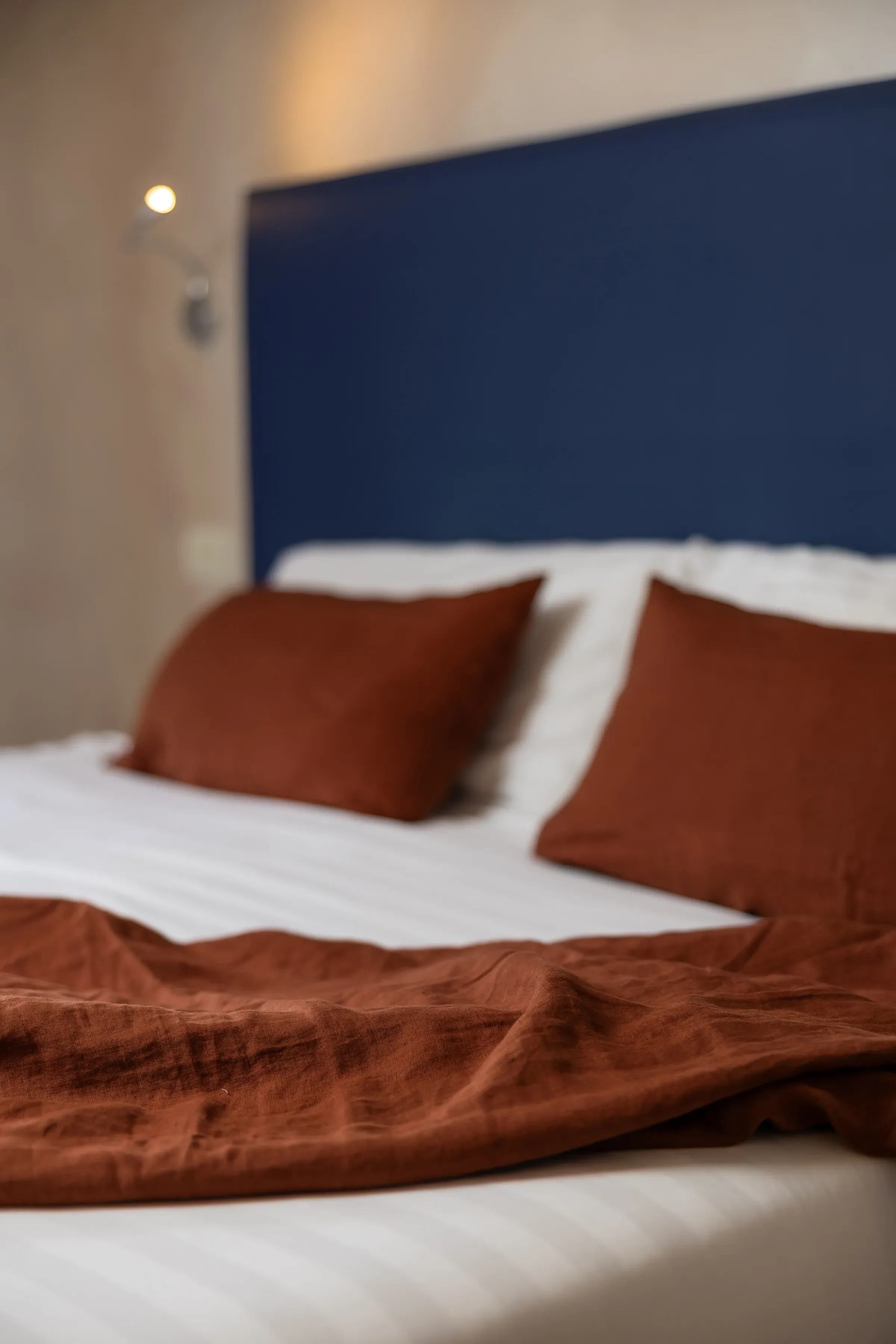 Letto con cuscini marroni e coperta abbinata