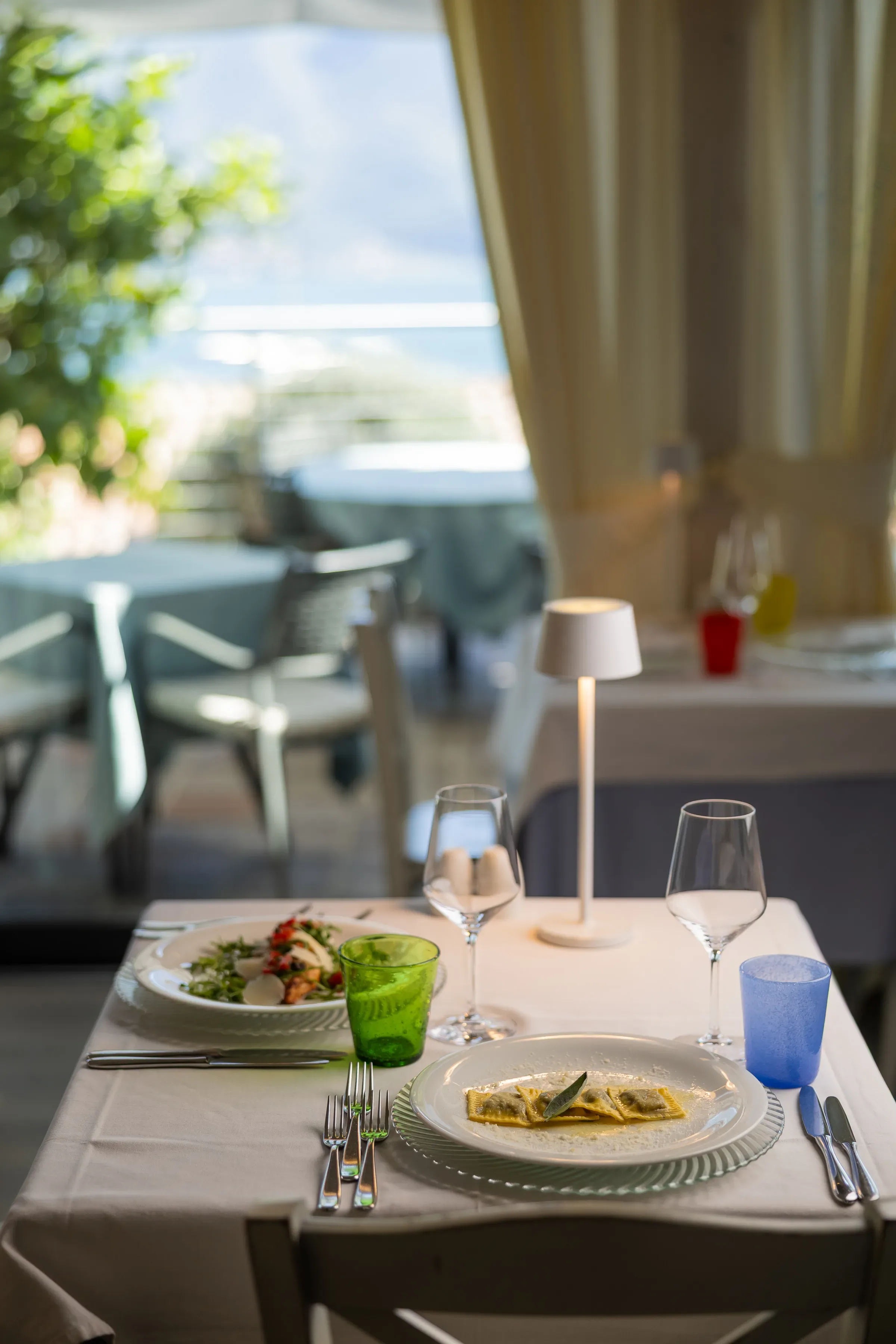 Elegant restaurant table setting with ravioli and salad plates