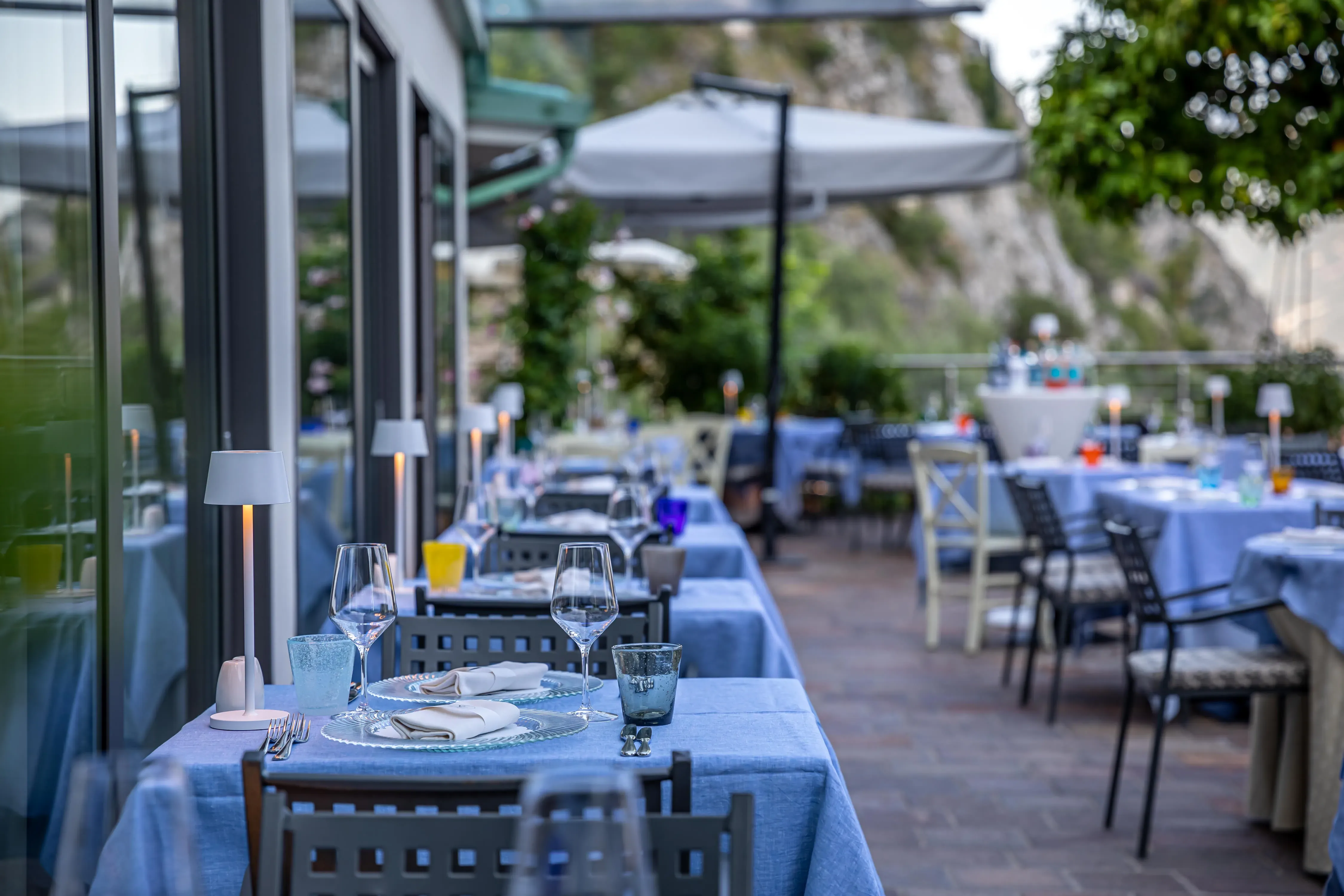 Tavoli apparecchiati in un ristorante all'aperto con vista sulle colline