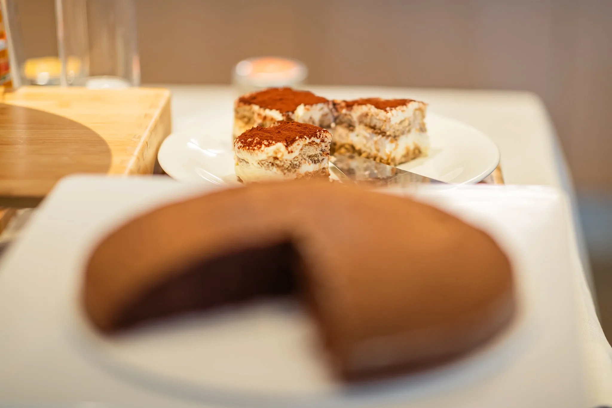 Fette di tiramisù e torta al cioccolato su piatti da dessert