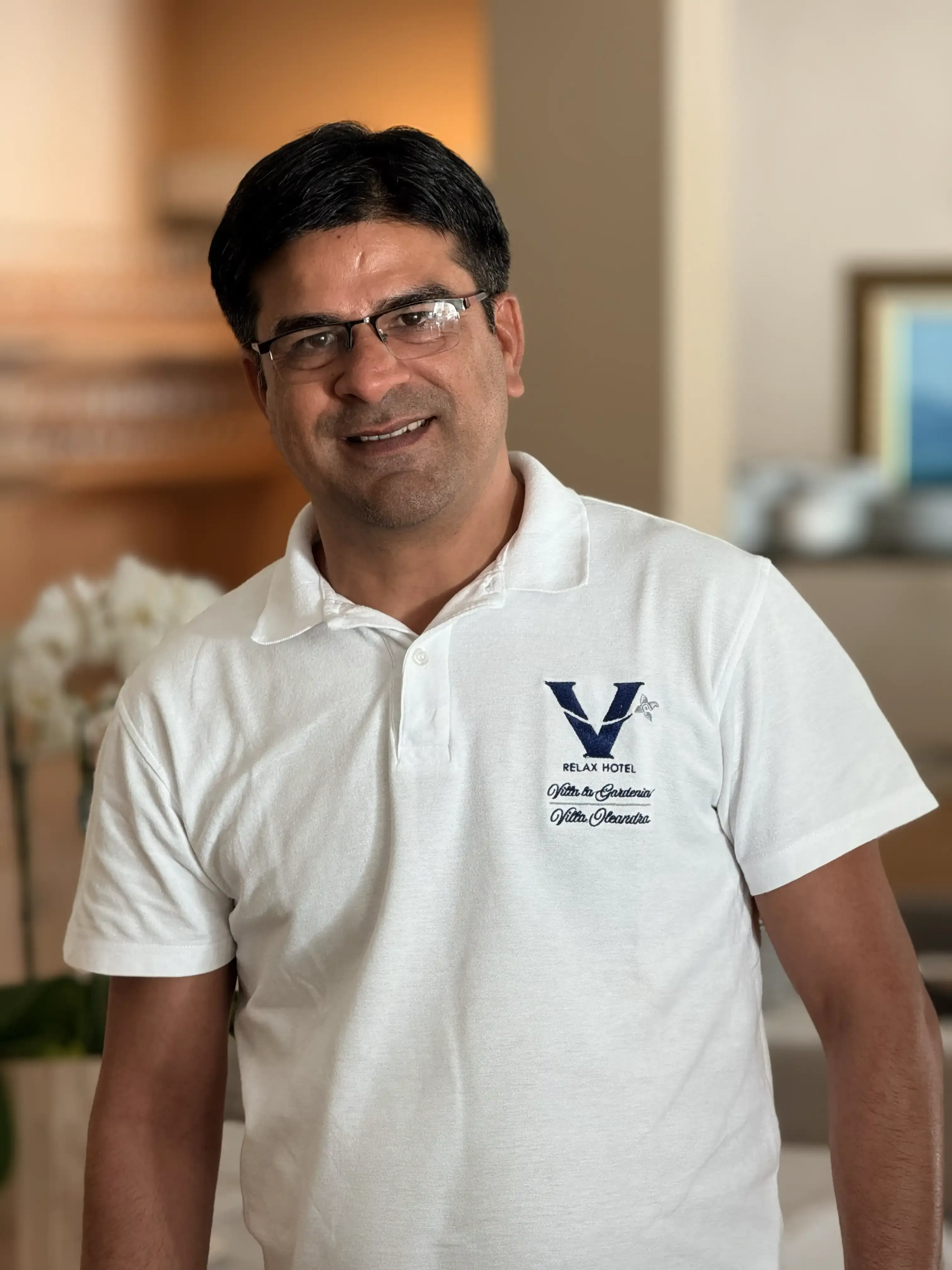 Uomo sorridente con occhiali in una hall di hotel