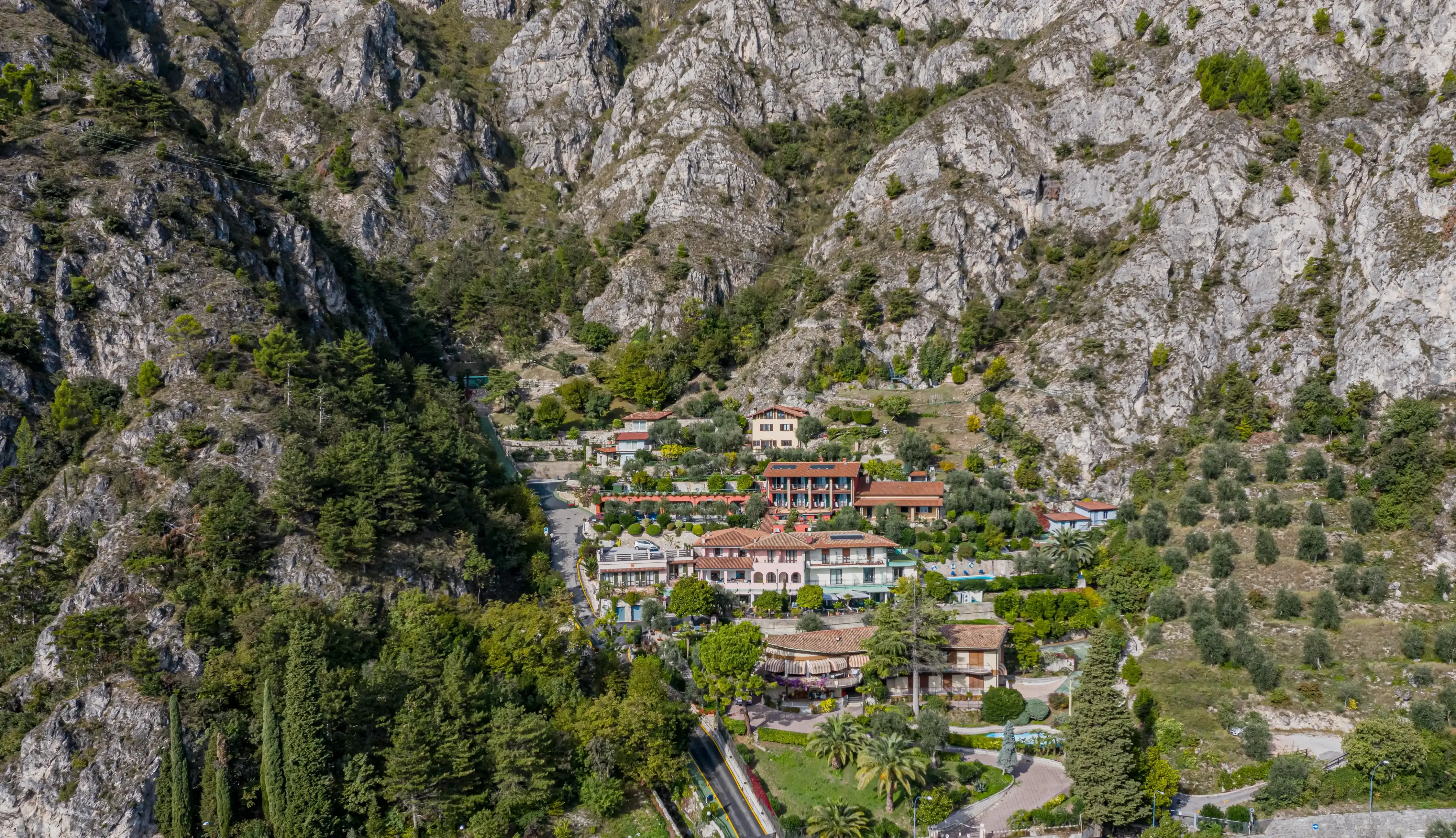 Vista aerea di un villaggio tra le montagne rocciose e alberi verdi