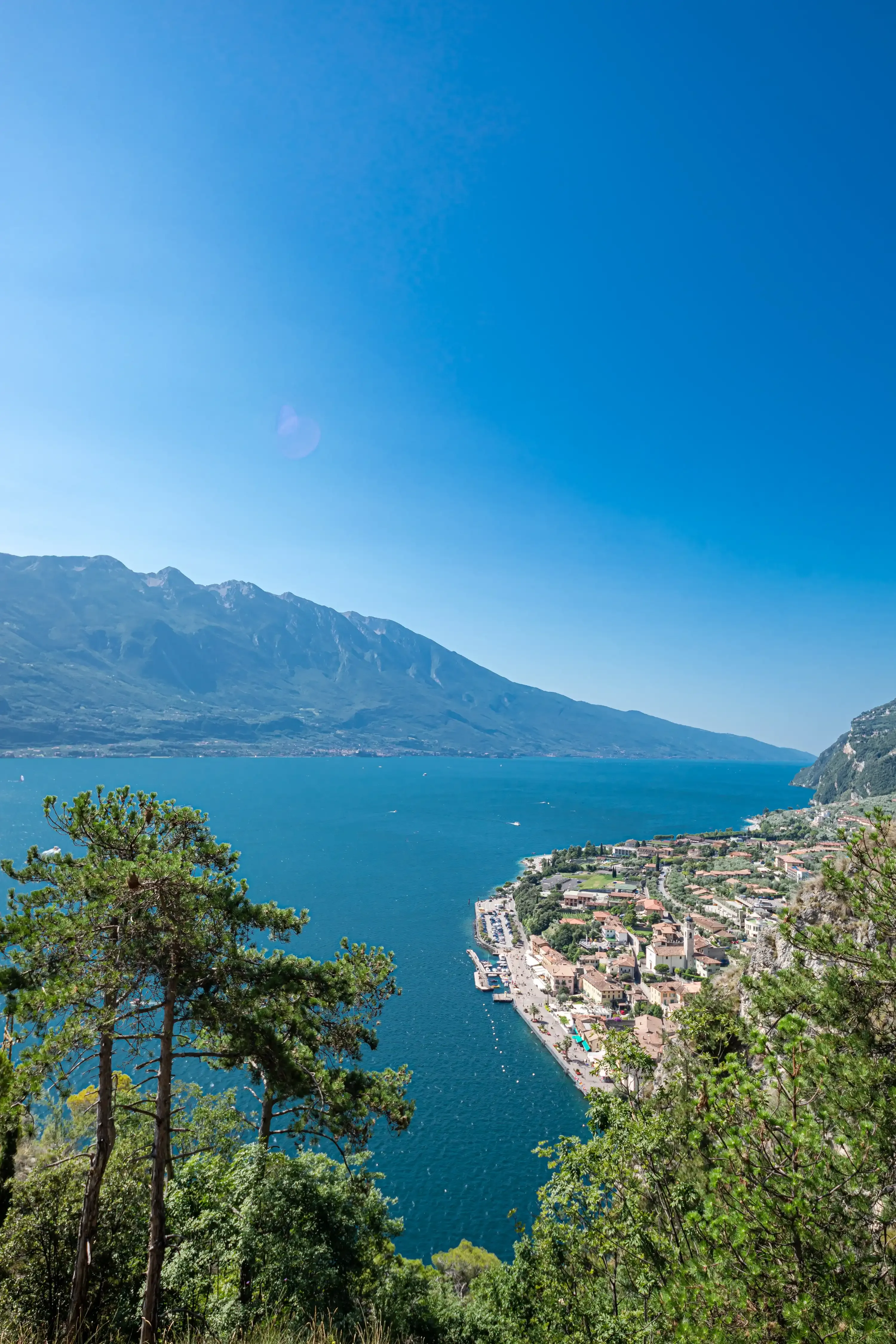 Vista panoramica del lago con montagne e città costiera