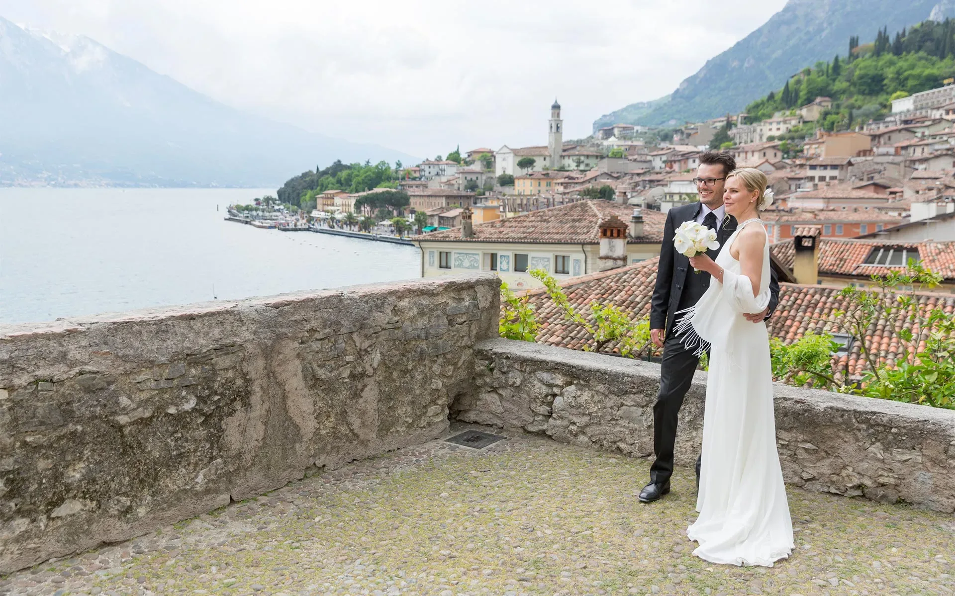 Wedding couple posing with scenic lake and town view